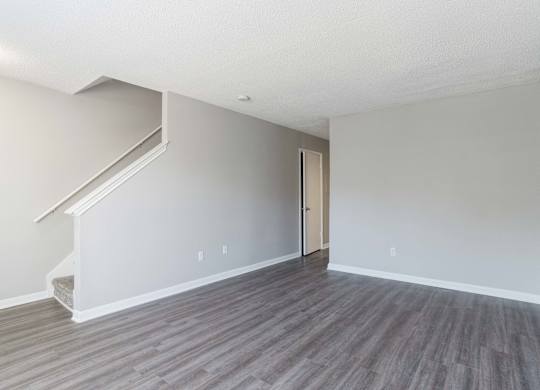 A room with a wooden floor and a staircase leading to the upper floor.at Jamestown Pointe Apartments, South Carolina, 29607