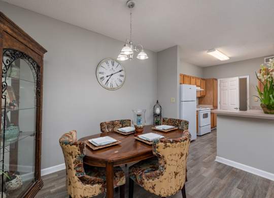 a dining room and kitchen with a large clock on the wall at Magnolia Lake Apartments, Georgia 30117