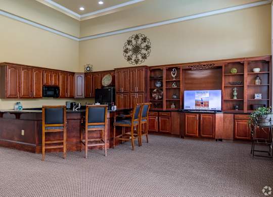 a break room with a table and chairs and a television at Magnolia Lake Apartments, Carrollton, GA, 30117