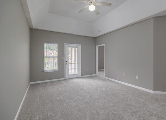 an empty living room with grey walls and a ceiling fan at Magnolia Lake Apartments, Carrollton, Georgia