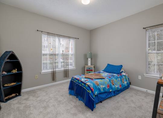 a bedroom with a bed and two windows at Magnolia Lake Apartments, Georgia 30117