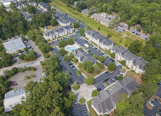 arial view of a neighborhood with houses and a swimming pool at Palms on Ashley River Apartments, Ladson, SC