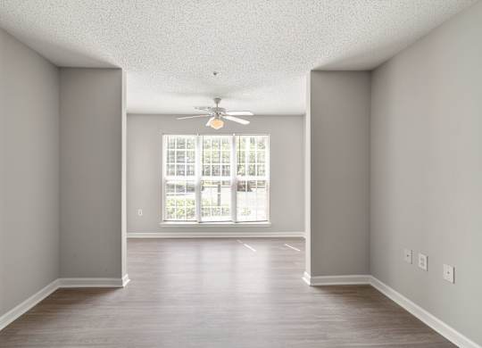 an empty living room with a ceiling fan at Palms on Ashley River Apartments, Ladson, South Carolina