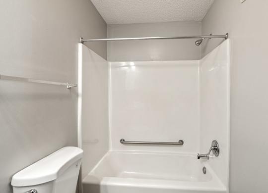 a bathroom with a bathtub and a toilet at Palms on Ashley River Apartments, South Carolina