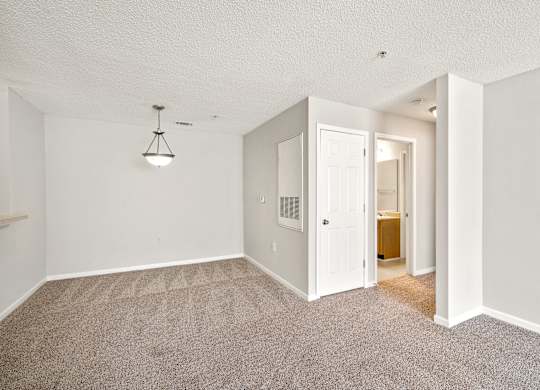 a living room with a carpeted floor and a doorway into a bathroom at Palms on Ashley River Apartments, Ladson, SC, 29456