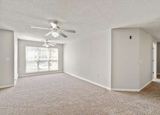 an empty living room with a ceiling fan at Palms on Ashley River Apartments, South Carolina 29456