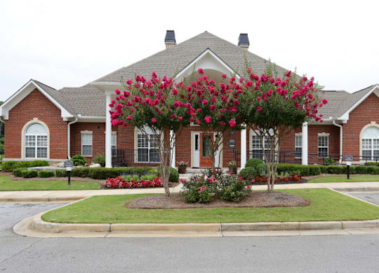 a house with a large flowering tree in front of it at Magnolia Lake Apartments, Carrollton, GA