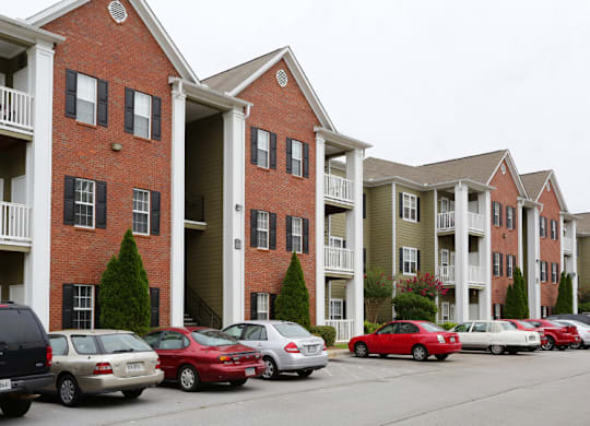 a photo of a street with cars parked in front of an apartment building at Magnolia Lake Apartments, Carrollton