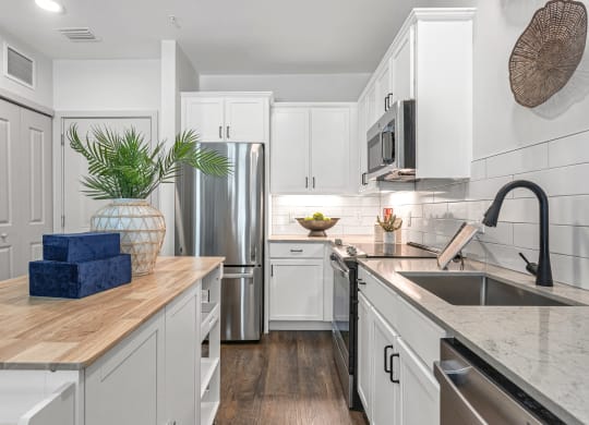 a kitchen with white cabinets and stainless steel appliances and a sink at Casa Marti, Tampa, 33605