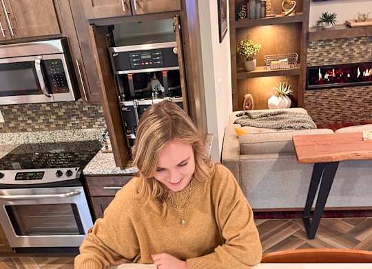 A woman is playing a board game in a kitchen.