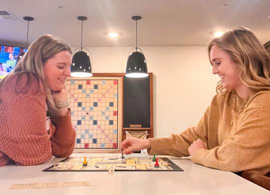 Two women playing a board game together.