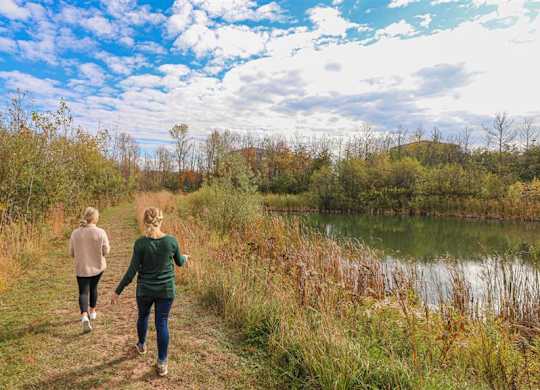 two women walking along a trail next to a lake at Boulder Ridge, Minnesota