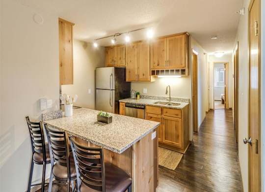 a kitchen with a marble counter top and wooden cabinets at Campus Park, Minnesota, 55811