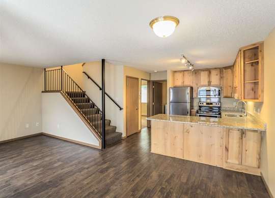 a living room with a kitchen and a staircase at Campus Park, Duluth, MN, 55811