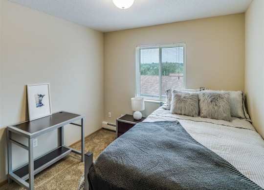 a bedroom with a bed and a desk and a window at Campus Park, Duluth, 55811