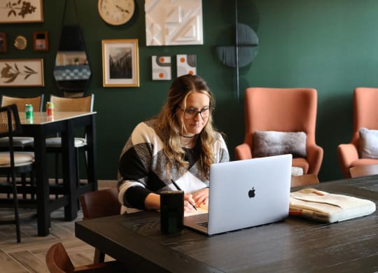 a woman sitting at a table using a laptop computer  at Timber Ridge, Forest Lake