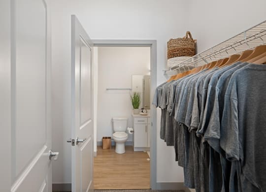 A bathroom with a toilet, a plant, and a rack of towels.at Converge KC Uptown, Kansas City, 64111