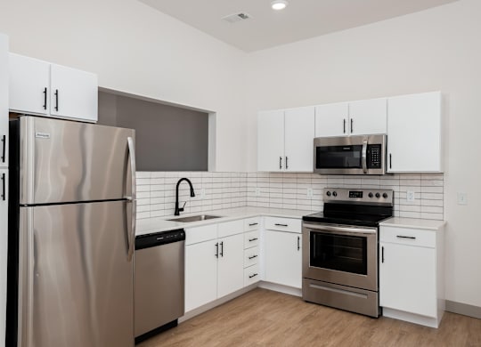 A modern kitchen with a stainless steel refrigerator and oven.at Converge KC Uptown, Kansas City, 64111