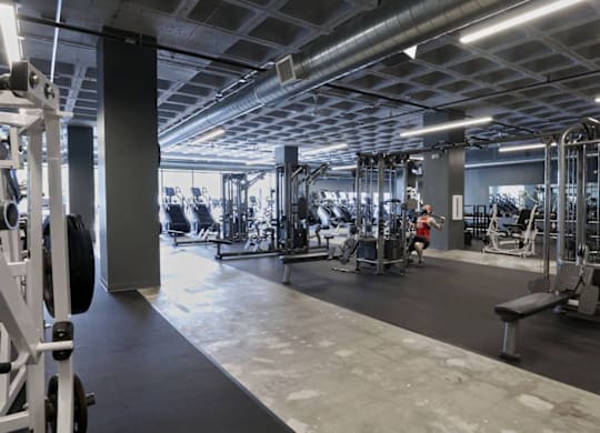 A gym with various exercise equipment and a person working out.at Converge KC Uptown, Kansas City, MO 64111