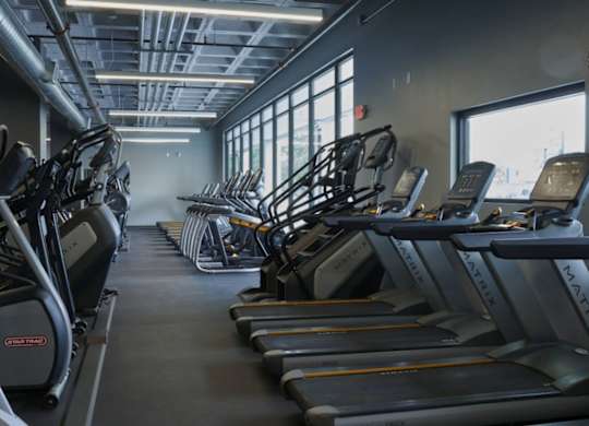 A gym with treadmills and elliptical machines.at Converge KC Uptown, Kansas City, 64111