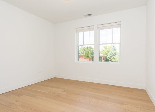a room with white walls and a window and wooden floors
