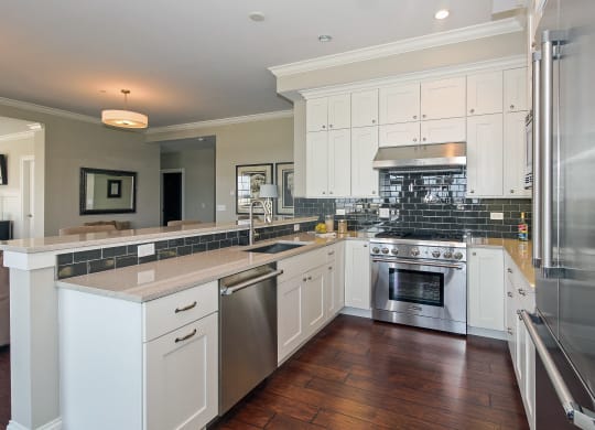 a large kitchen with white cabinets and stainless steel appliances