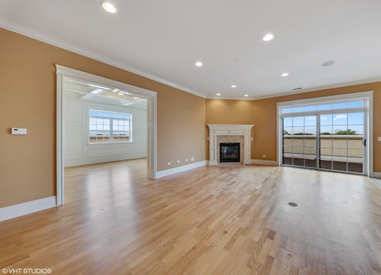 an empty living room with wood floors and a fireplace