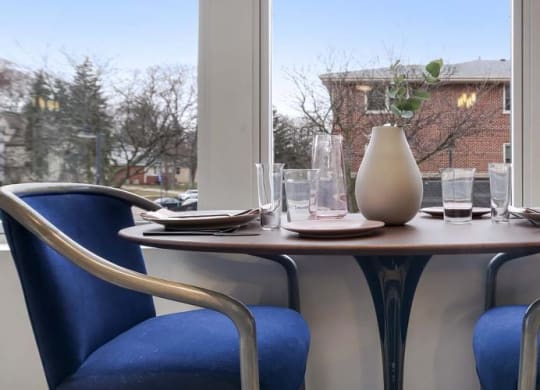 a table with two blue chairs and a white vase at Clarendon Hills 229, Illinois, 60514