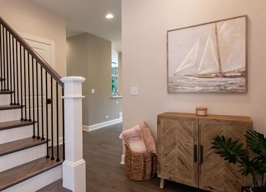 a living room with a staircase and a painting on the wall at Countryside Townhomes, Illinois, 60525