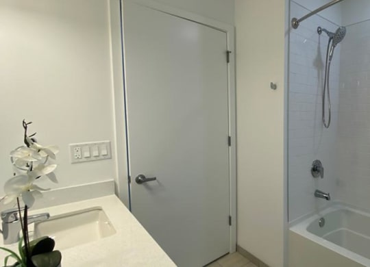 a white bathroom with a shower and a sink at Highwood 546, Highwood