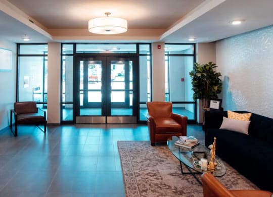 a lobby with a couch and chairs and a table at Barrington 101, Barrington, IL