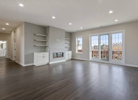 an empty living room with a fireplace and a large window