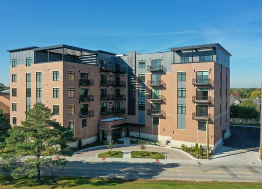 a brick apartment building with balconies and a sidewalk