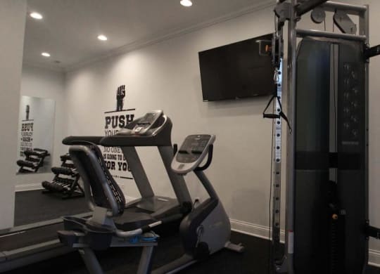 a gym with weights and a tv on the wall at Tripp 4321, Chicago, 60641