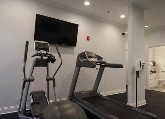 a gym with two machines and a tv on the wall at Tripp 4321, Chicago, 60641