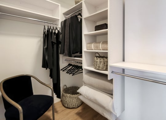 a walk in closet with a chair in front of a white closet door at Clarendon Hills 229, Clarendon, IL