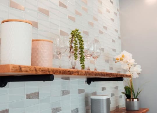 a shelf with wine glasses and flowers on it at Barrington 101, Chicago