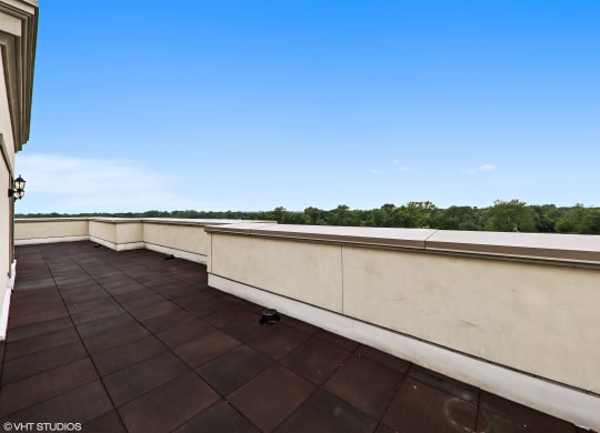 a balcony with a view of the water and a blue sky