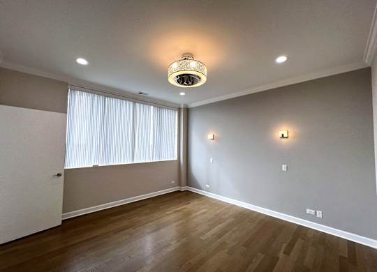 a living room with wood flooring and a large window