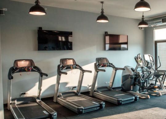 a gym with cardio equipment and a tv on the wall at Barrington 101, Illinois, 60010
