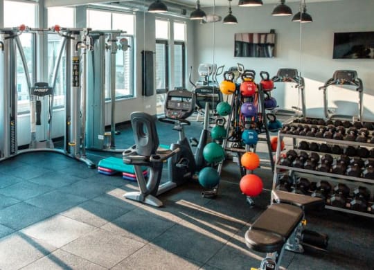 a gym with a lot of weights and a large window at Barrington 101, Chicago