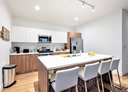 a kitchen with a large island and white chairs