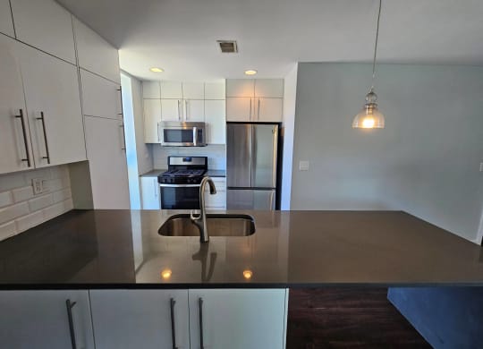 an empty kitchen with a counter top and a sink