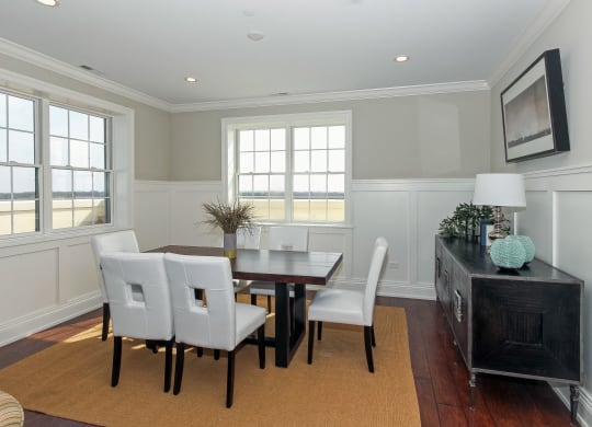 a dining room with a wooden table and white chairs