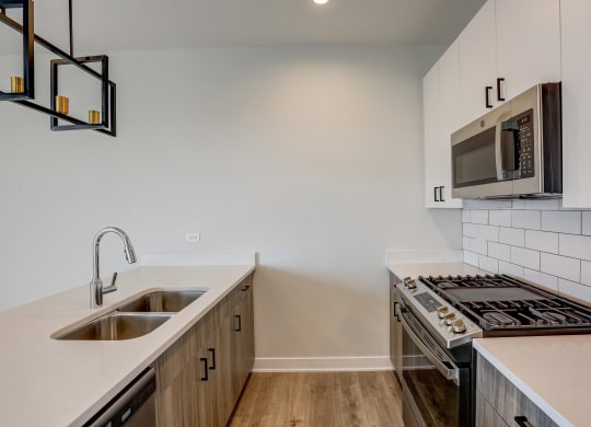 a kitchen with a sink and stove and a microwave