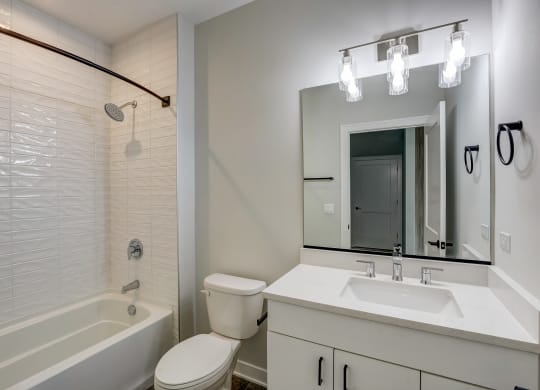 a bathroom with a mirror and a toilet and a tub