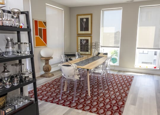 a dining room with a wooden table and chairs and a red rug