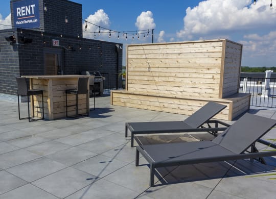 a outdoor balcony with lounge chairs and tables 
