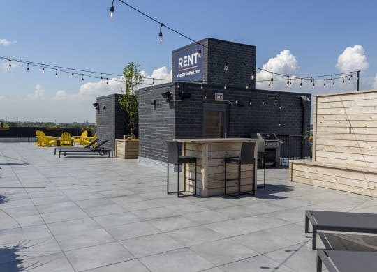 an outdoor patio with a grill and a bar on the roof of a building at Talman 1554, Chicago Illinois