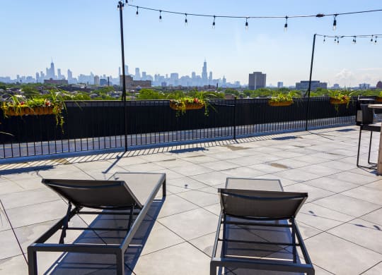 a patio roofdeck with lounge chairs and a view 